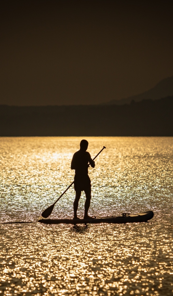 Мужчина серфингист в море на закате