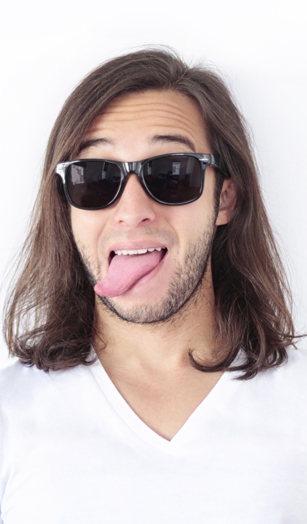 Мужчина в очках с высунутым языком