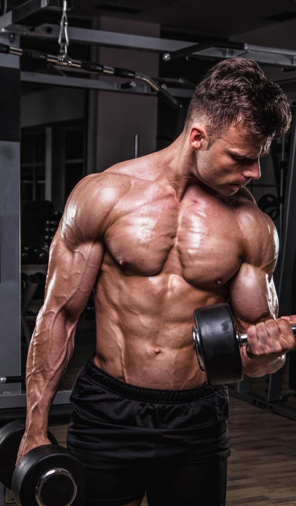 Сильный мужчина качает мускулы 