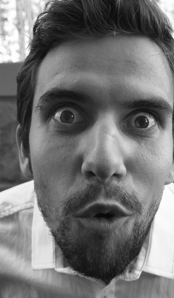 Удивленный взгляд мужчины в белой рубашке