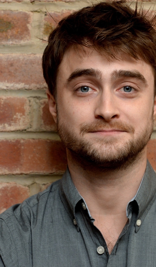 Актер Дэниел Рэдклифф стоит у стены