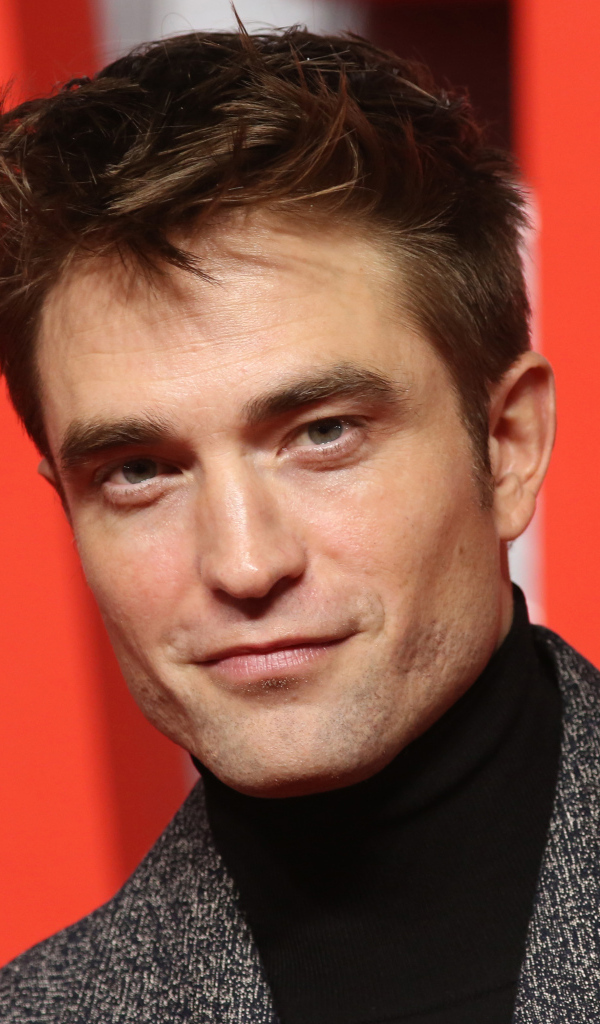 Актер Роберт Паттинсон на красном фоне