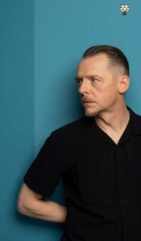 Актер Саймон Пегг  стоит у стены