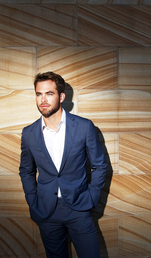 Американский актер Крис Пайн в костюме у стены