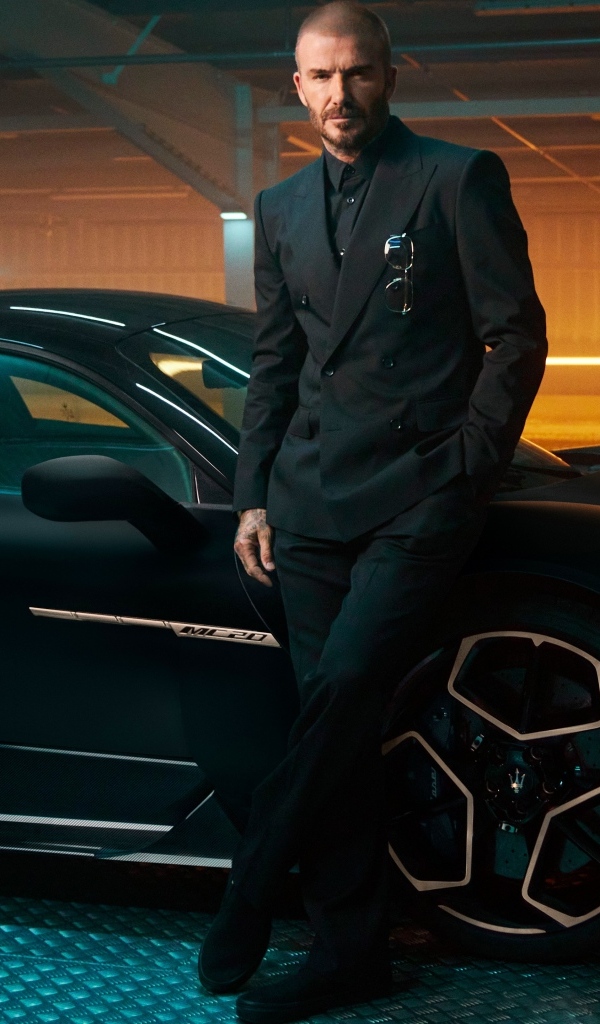 Футболист Дэвид Бекхэм у черного автомобиля Maserati MC20