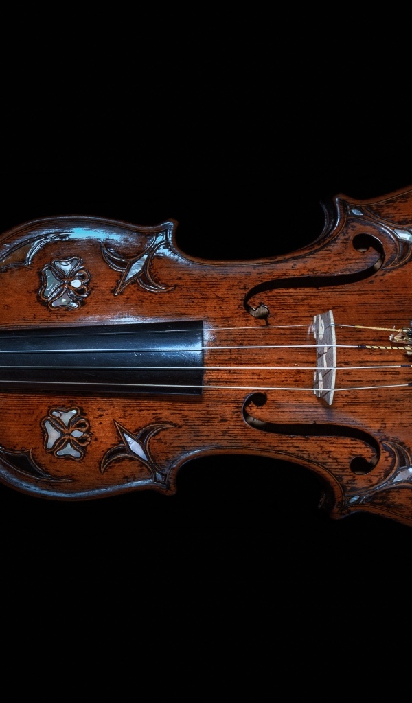 Большая деревянная скрипка на черном фоне