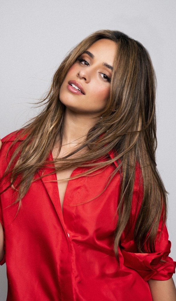 Певица Камила Кабельо в красной рубашке на сером фоне