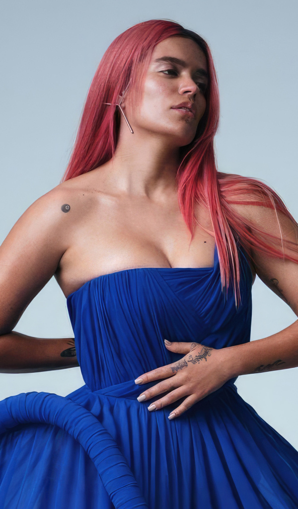 Певица Karol G в синем платье на сером фоне