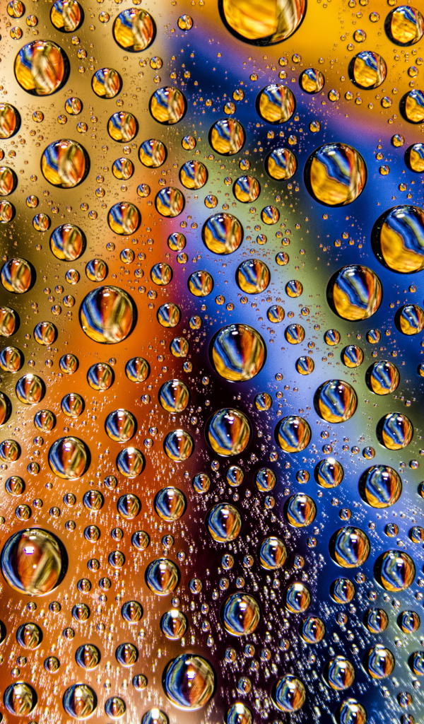 Капли воды на разноцветном стеклянном фоне