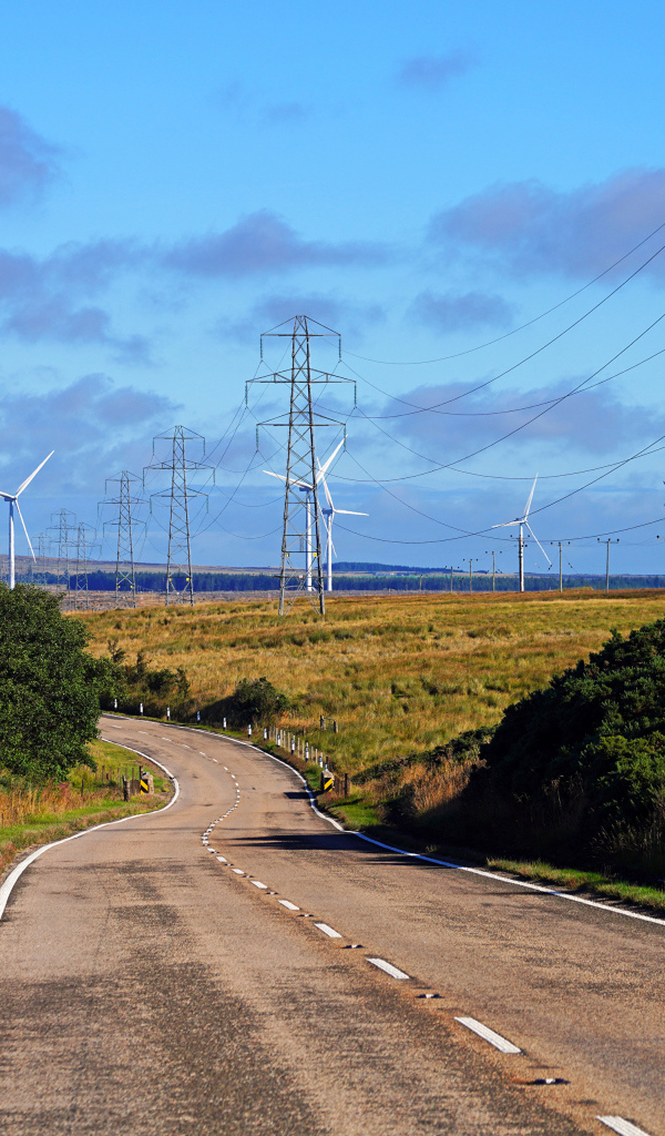 Ветрогенераторы в поле у дороги под голубым небом