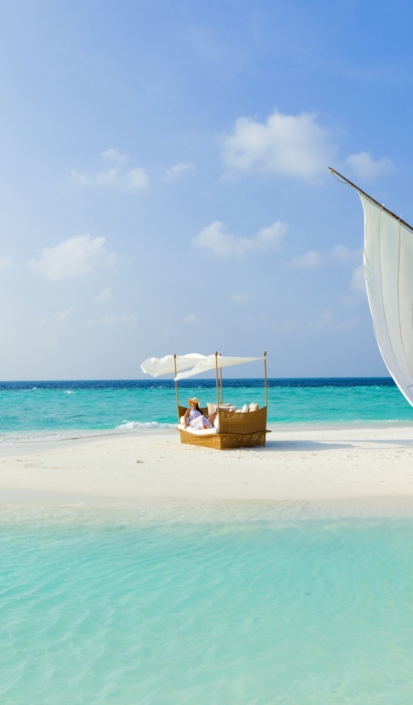 Лодка стоит на белом песке у голубого океана