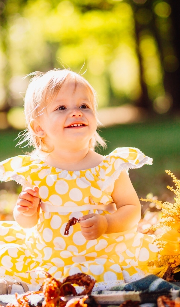 Малышка с цветами подсолнуха на траве