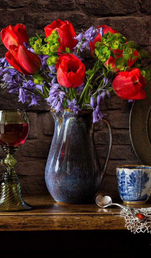 Букет цветов на столе со свечой и вином