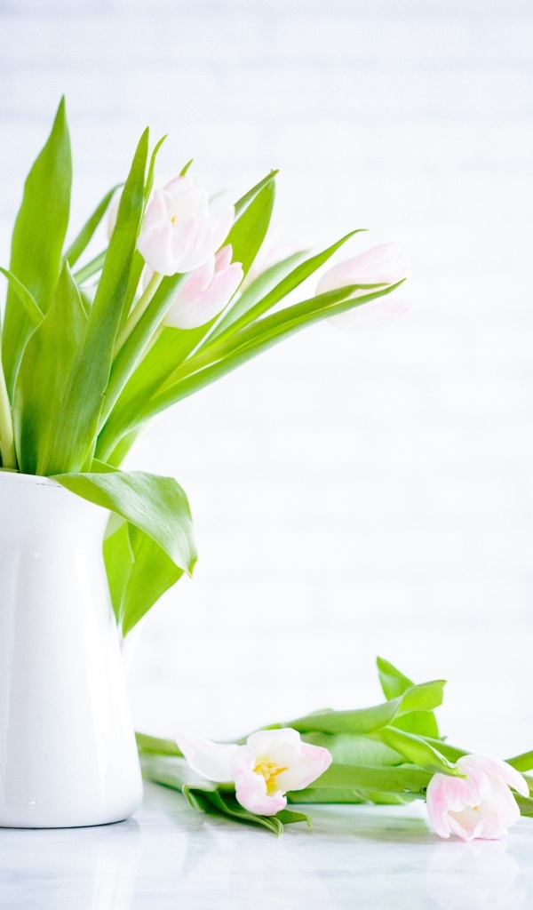 Букет розовых тюльпанов в белой вазе на столе