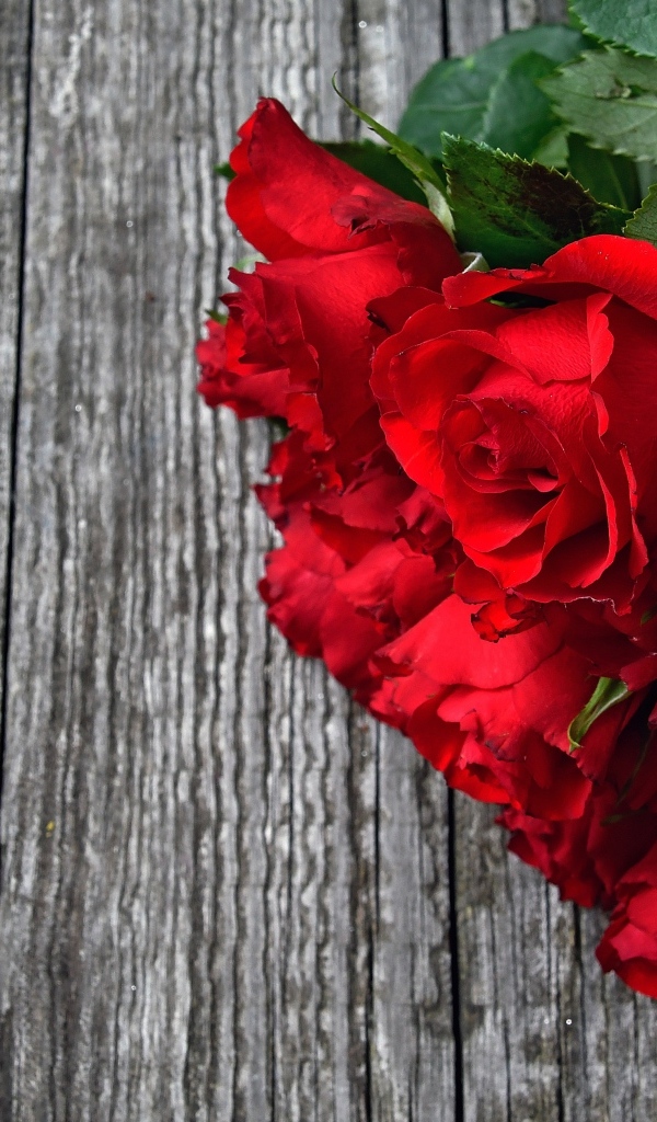 Букет красных роз на деревянном столе