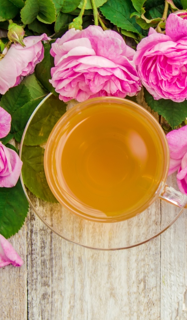 Букет роз с чашкой чая на столе