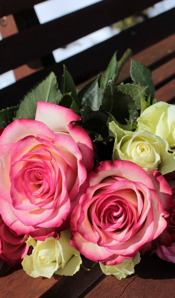 Букет белых и розовых роз на деревянной лавке