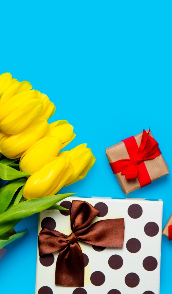Букет желтых тюльпанов с подарками на голубом фоне