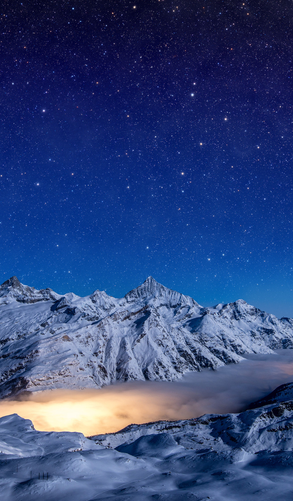 Красивое ночное небо над покрытыми снегом горами