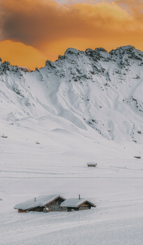 Красивая заснеженная гора под оранжевым небом