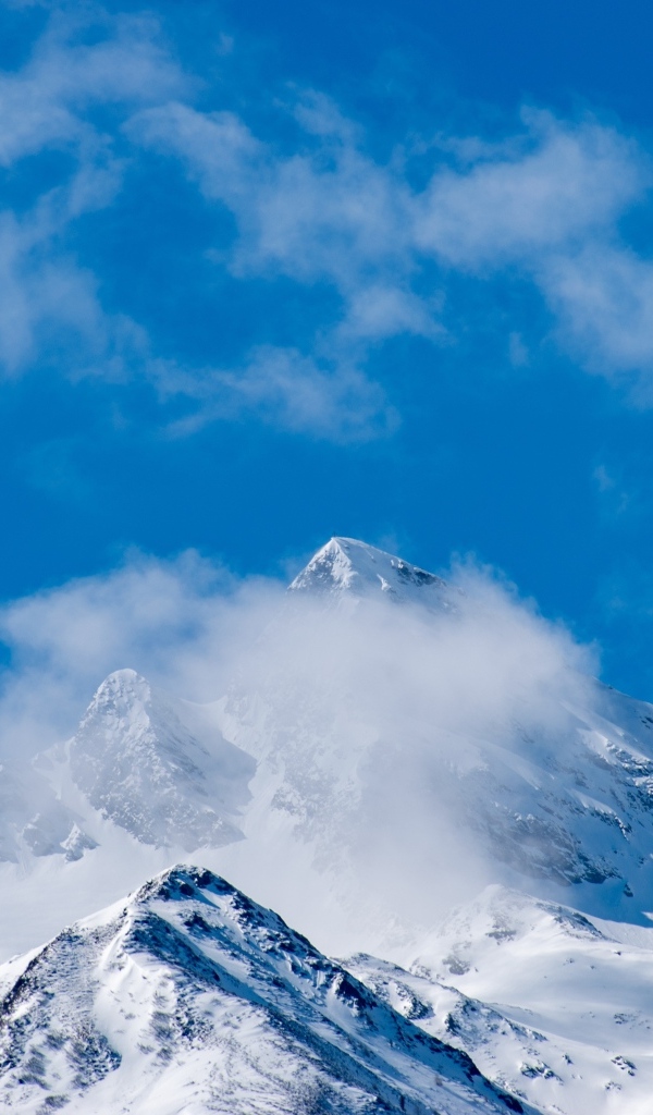 Голубое небо над покрытыми снегом горами