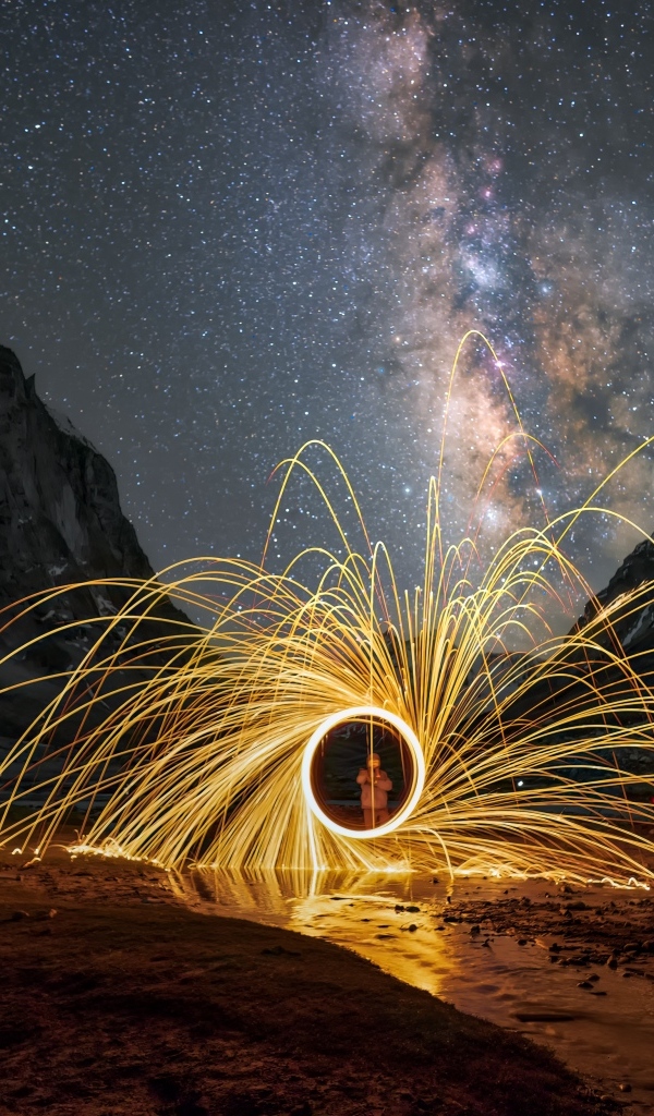 Огненное шоу под ночным красивым небом в горах