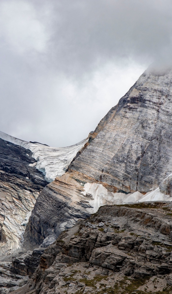 Высокие каменные горы в белых облаках
