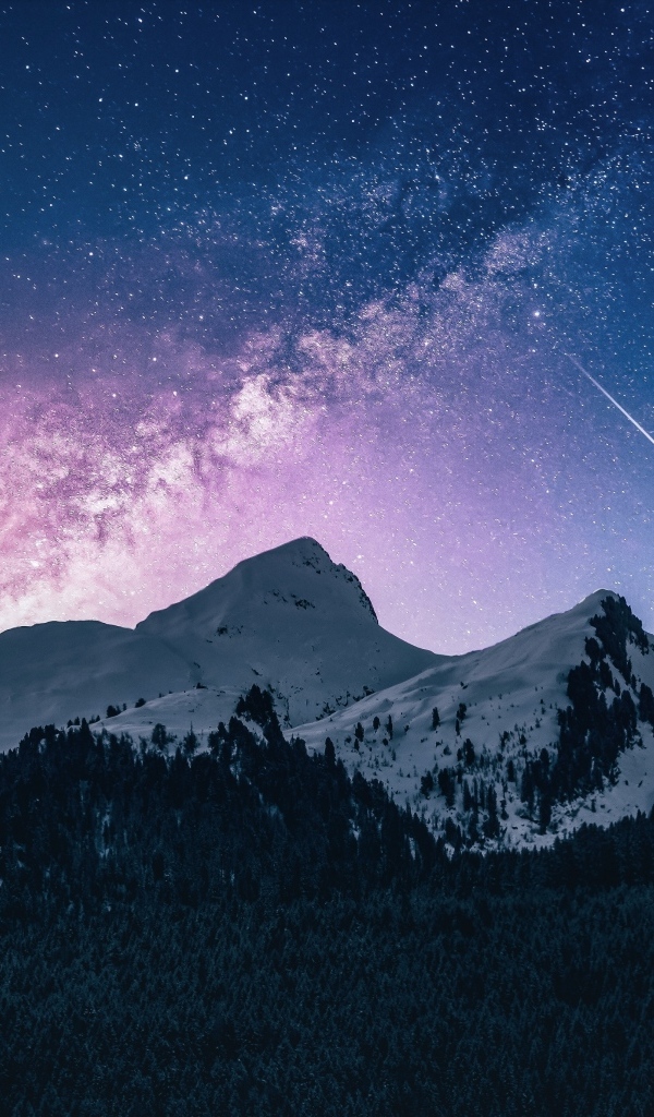 Млечный путь в звездном небе над заснеженными горами