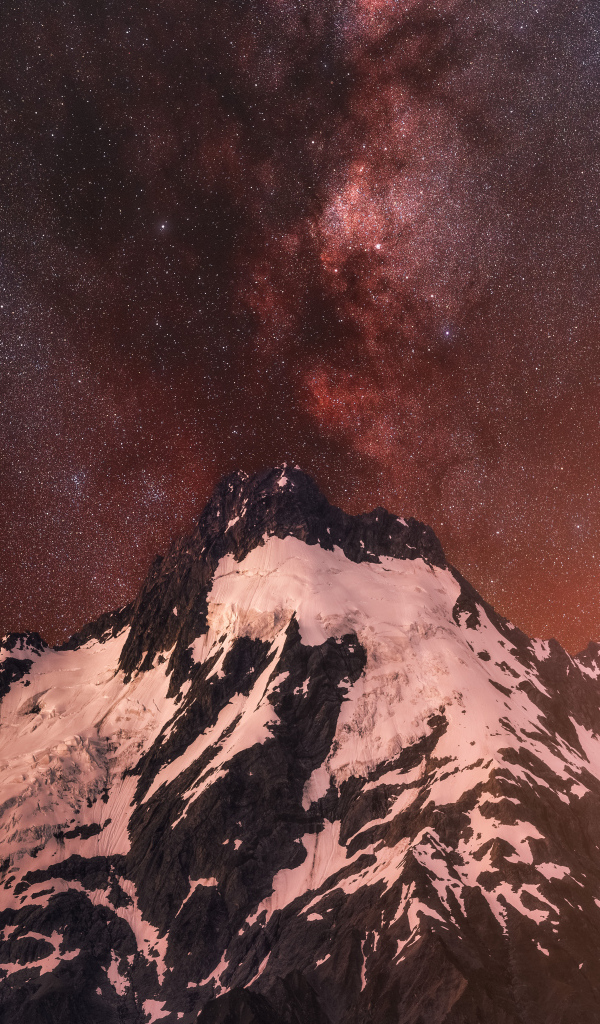Заснеженная вершина горы под звездным небом