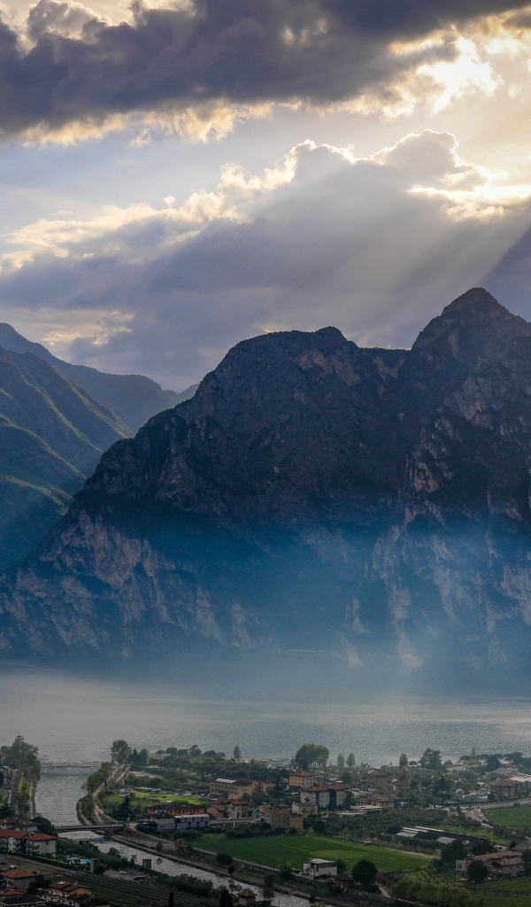 Лучи солнца покрывают горы и город 
