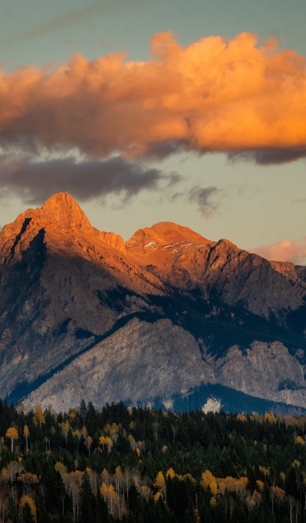 Солнце в облаках освещает вершину горы