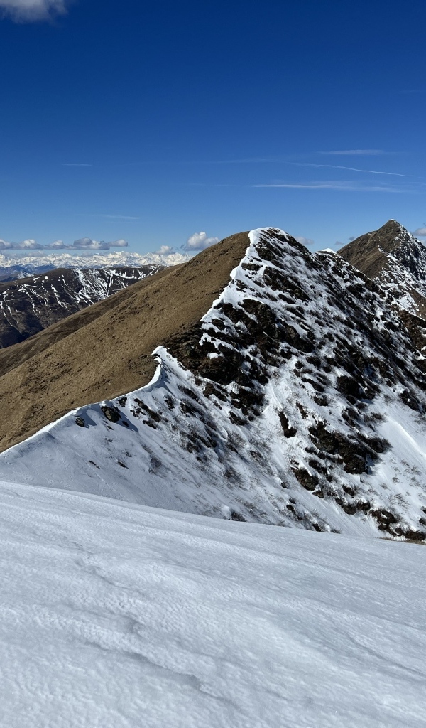 Вид на заснеженную гору под голубым небом