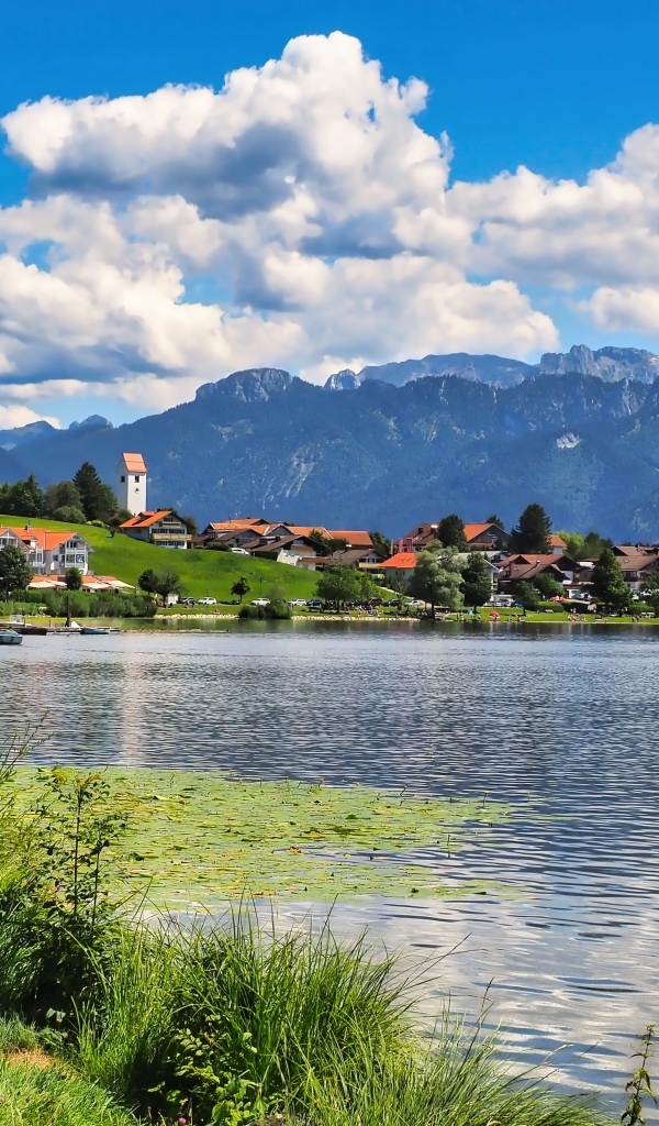 Красивый вид на озеро и горы под голубым небом с белыми облаками