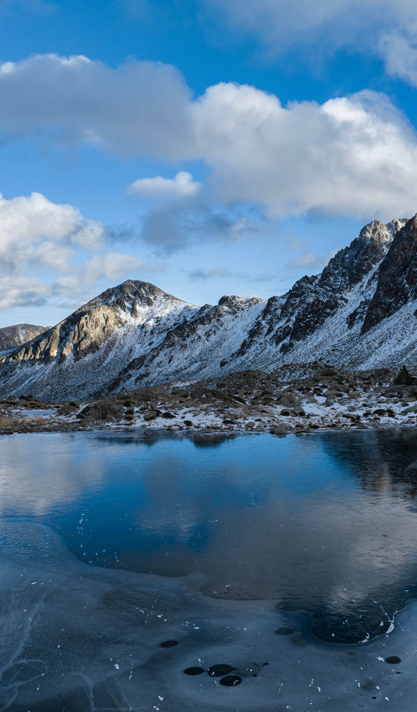 Холодный мороз покрывает льдом воду горного озера