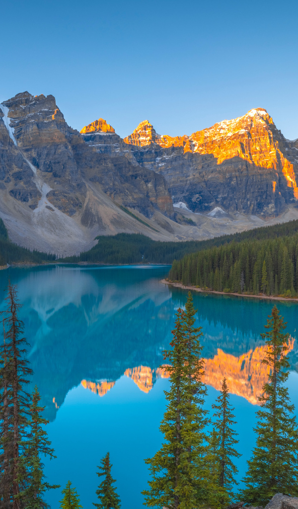 Солнце над вершинами гор у голубого озера