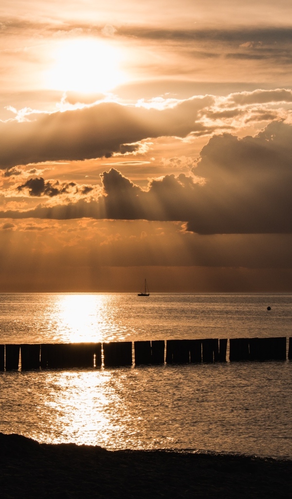 Яркое солнце за облаками над морем