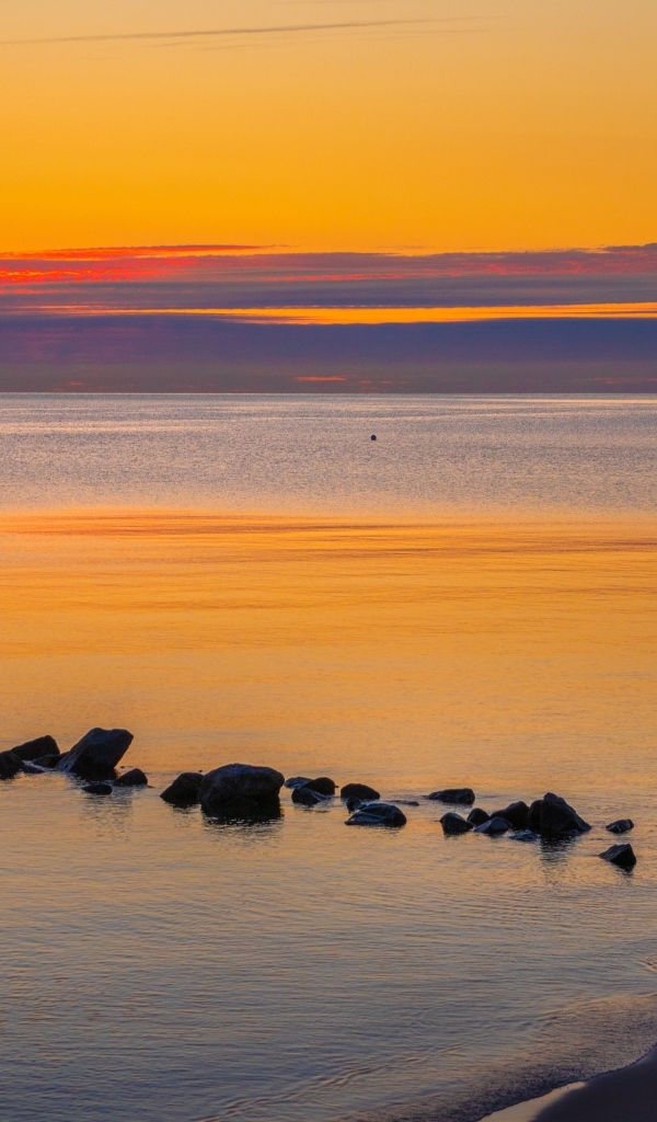 Спокойное теплое море на закате в сумерках