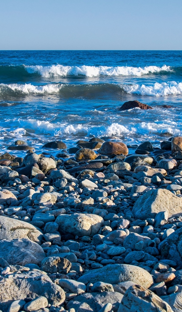 Большие камни на берегу моря с белыми волнами