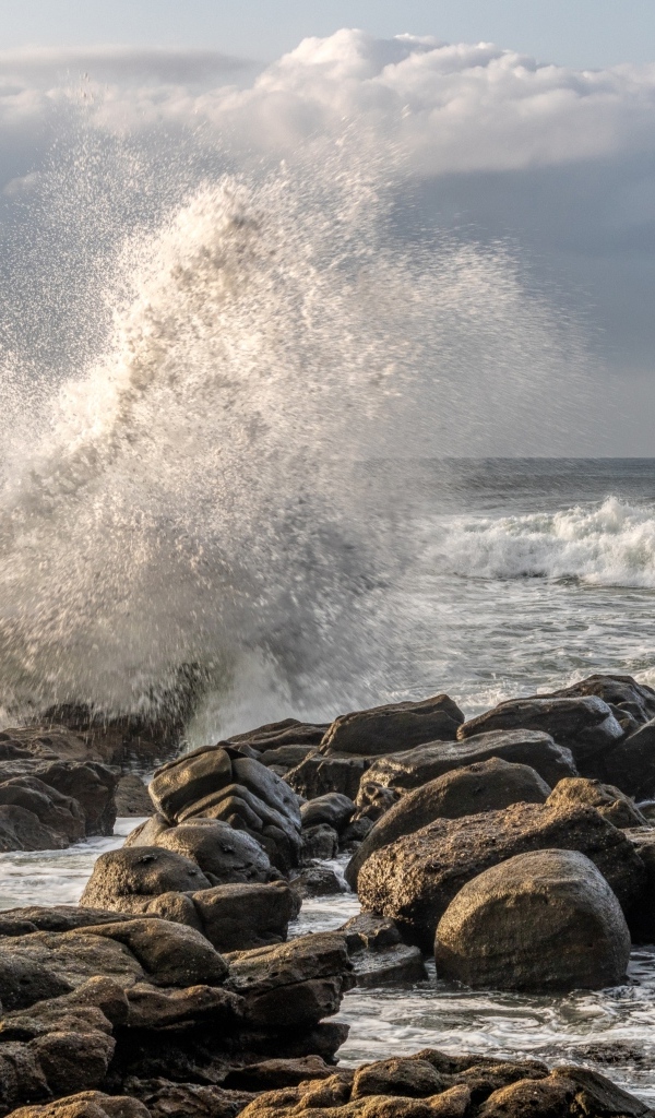 Морские волны бьются о камни на берегу