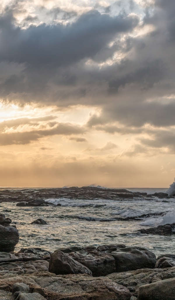 Лучи солнца пробиваются сквозь тучи над морем