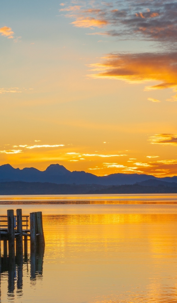 Красивый закат в небе над тихой водой озера
