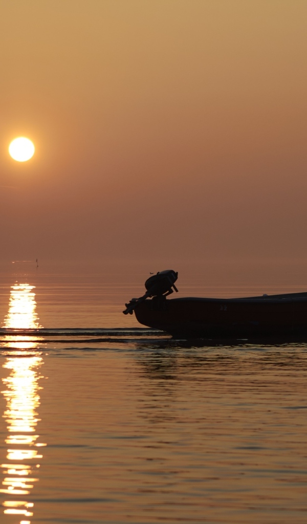 Лодка в море на закате солнца