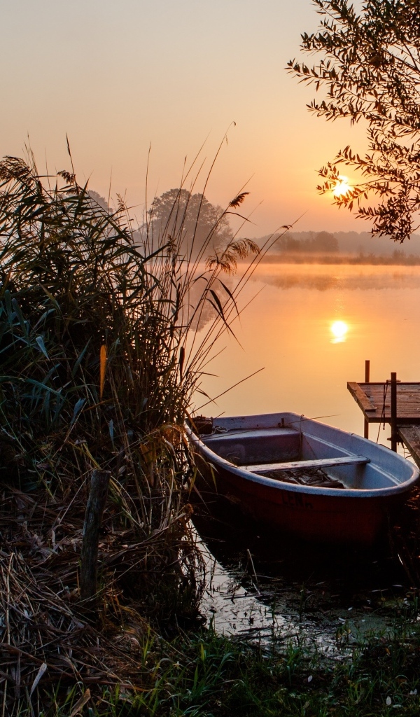 Лодка на берегу озера на закате 