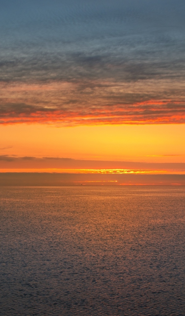 Яркий оранжевый закат на морском горизонте