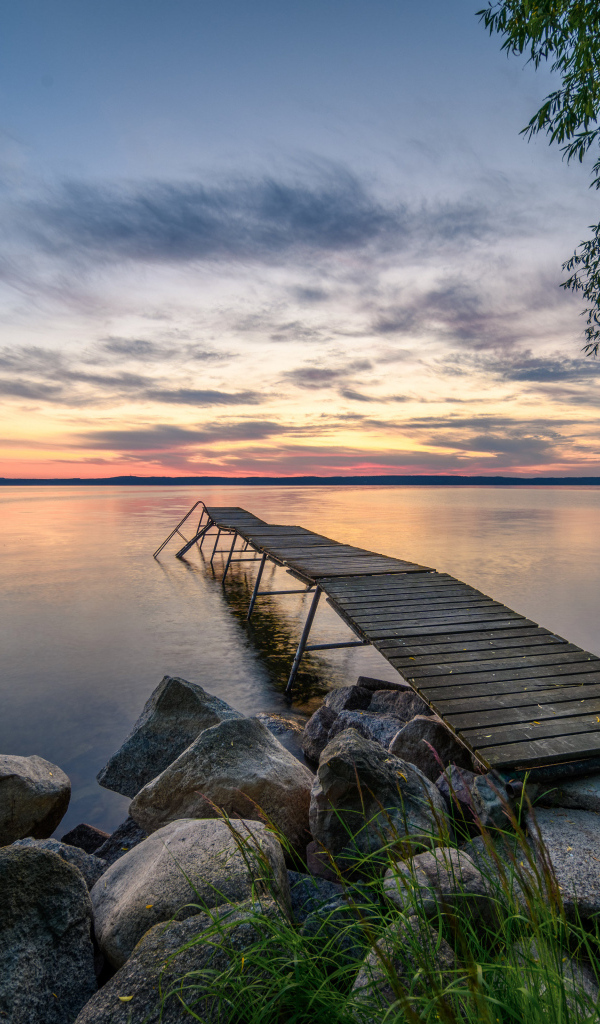 Старый деревянный пирс у озера на закате