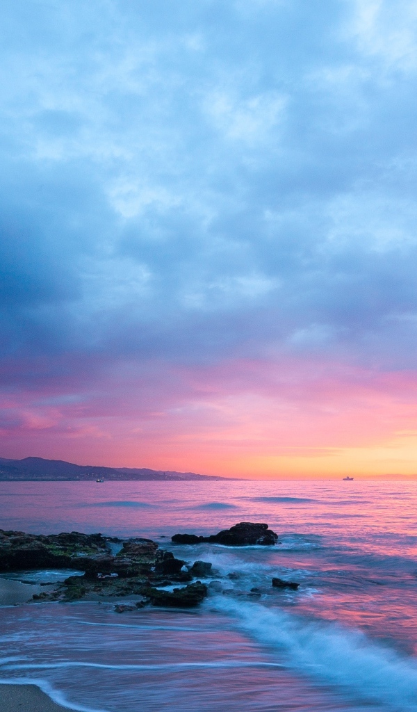 Розовый закат в пасмурном небе над морем