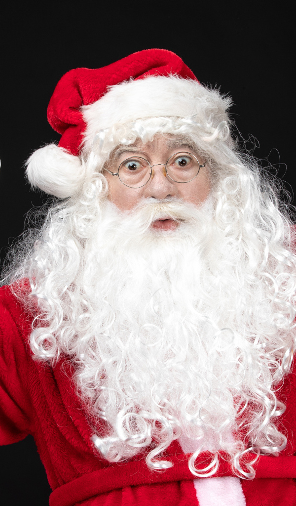 Удивленный Санта Клаус с колокольчиком в руках