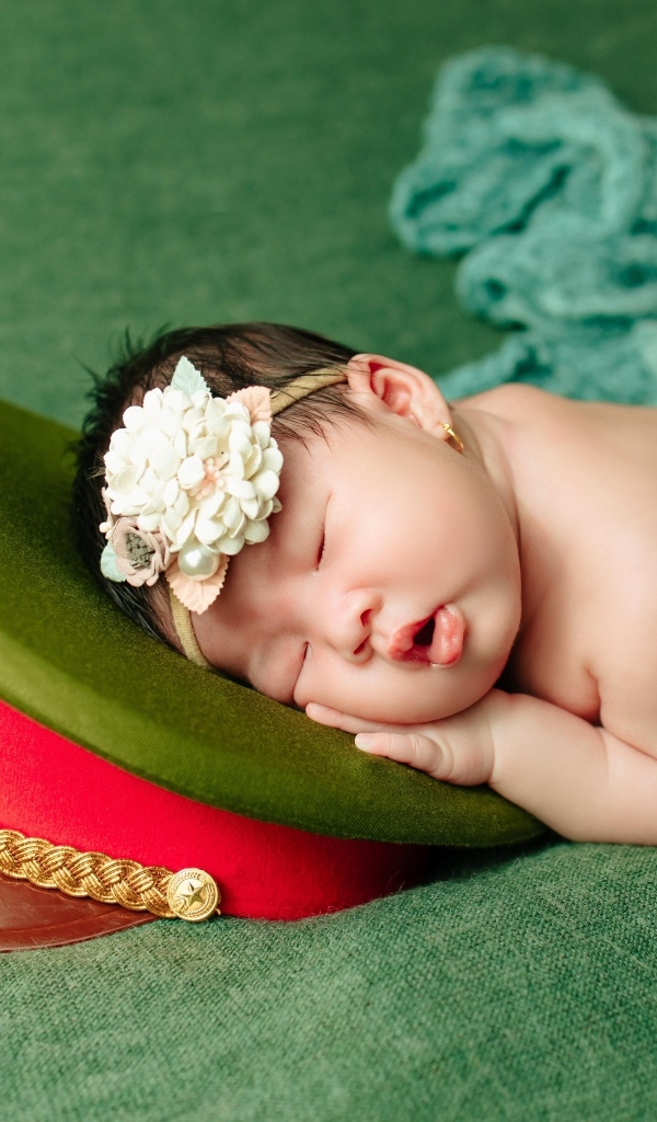 Маленький ребенок спит на военной фуражке