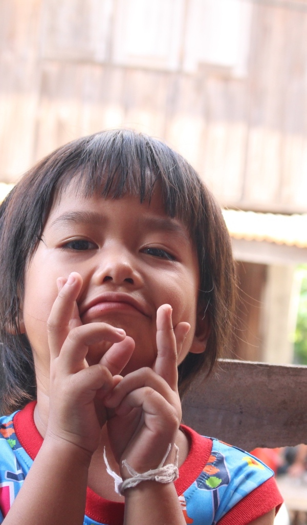 Девочка азиатка с руками  у лица