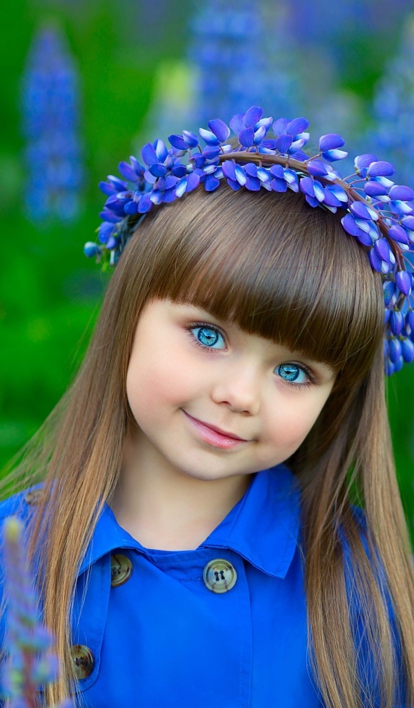 Красивая маленькая девочка в цветах люпина